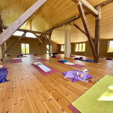 Im hellen Yoga Raum den Tag mit einem Sonnengruß beginnen Im hellen Yoga Raum den Tag mit einem Sonnengruß beginnen