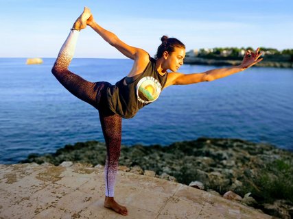 Frau am Meer in Yogapose