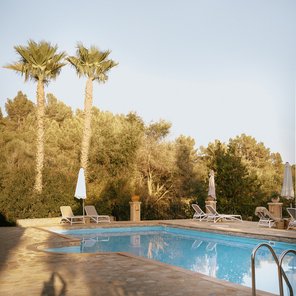 Pool mit Palmen und Liegestühlen
