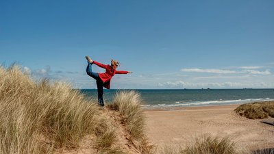 Yoga üben inmitten von Dünen