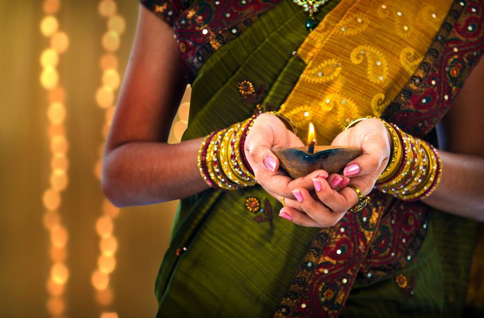 Indische Frau hält eine Kerze