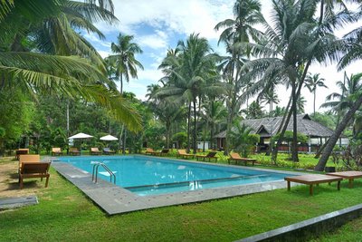 Entspannen Sie sich zwischen den ayurvedischen Anwendungen am Pool unter Palmen