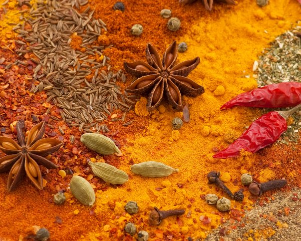 Gelb und Orange farbene Gewürze in Pulver und Ursprungsform
