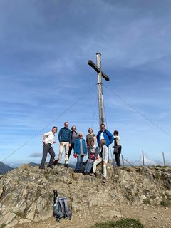 Strahlende Gesichter der Reisegruppe an dem Gipfelkreuz