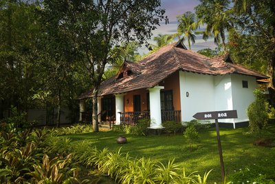 Im tropischem Grün stehen 20 Cottages im traditionellen Kerala-Stil