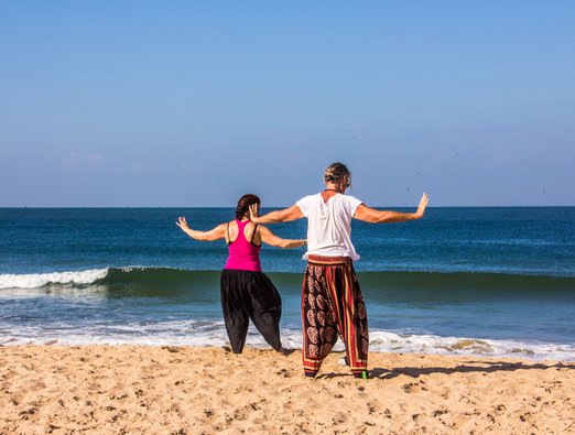 Zwei Frauen üben Qi Gong an einem Strand