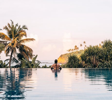 Eine Frau im Pool Blick auf das Meer