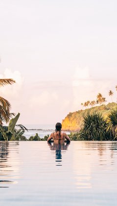Eine Frau im Pool Blick auf das Meer