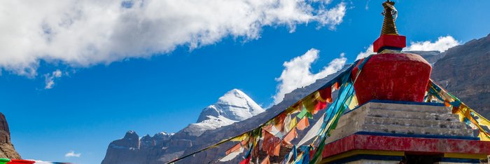 Bunte Gebetsfahnen an einem kleinen Tempel befestigt