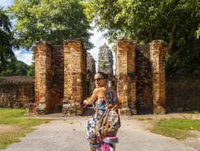 Eine Frau fährt auf einem Fahrrad in einem Park