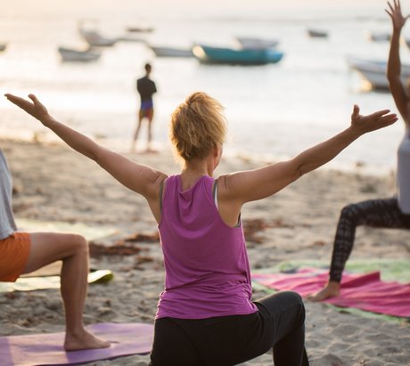 Eine Gruppe übt Yoga am Strand