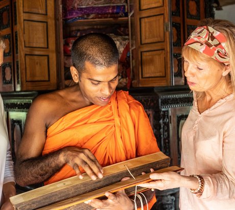 Zwei Frauen und ein Mönch bei einer Palmblattlesung