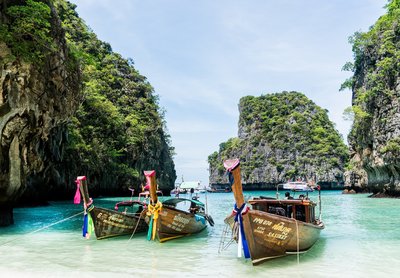Die typischen geschmückten Boote in Thailands paradiesisch blau weißen Stränden