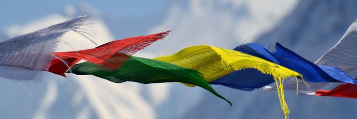 Bunte Fahnen vor schneebedeckten Bergen