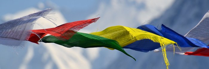 Bunte Fahnen vor schneebedeckten Bergen