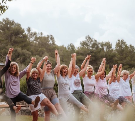 Eine Gruppe Frauen hält sich lachend an den Händen