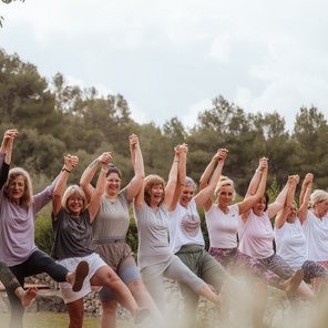 Eine Gruppe Frauen hält sich lachend an den Händen