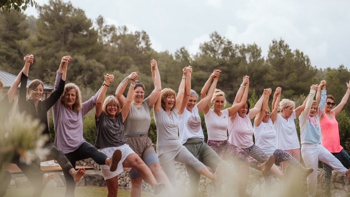 Eine Gruppe Frauen hält sich lachend an den Händen
