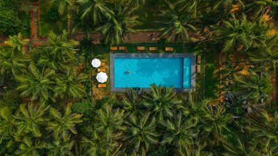 Der Pool inmitten der grünen Anlage des Ayur On The Beach Nattika