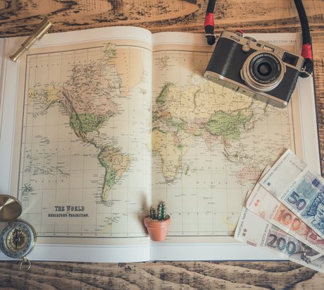 Eine Landkarte mit einer Fotokamera und weiteren Reiseutensilien