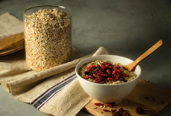 Ein Tisch mit mit einer Schüssel Müsli und einem Glas Haferflocken