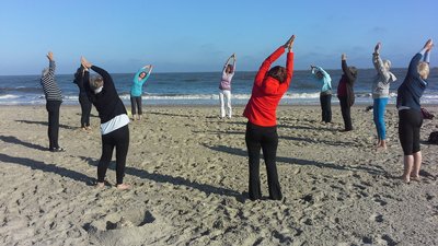 Entspannen Sie bei einer Yoga-Einheit in einer Gruppe am Strand