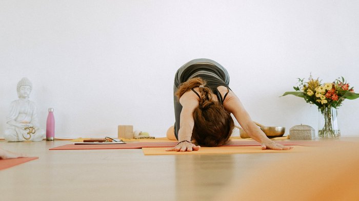 Eine Frau beim Yoga-Unterricht in der Child's Pose