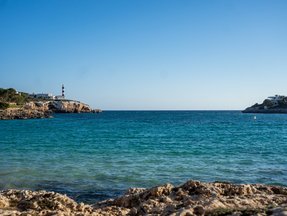 Das Meer umgeben von Steinen auf denen in der Ferne Gebäude stehen