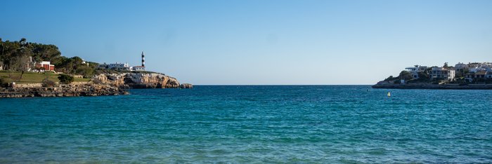 Das Meer umgeben von Steinen auf denen in der Ferne Gebäude stehen