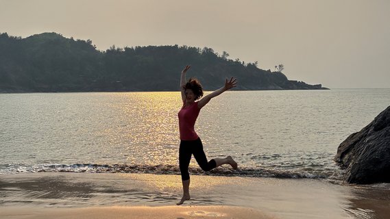 Frau springt am Strand