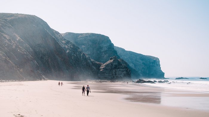 Ein Strand mit weißem Sand und einer Steilküste