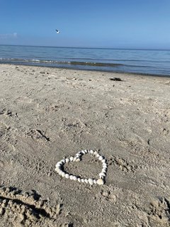 Ein Herz aus weißen Steinen am Strand