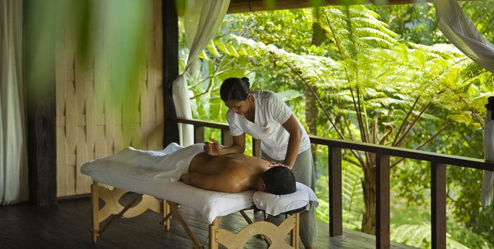 Ein Mann wird von einer Frau auf einer Liege massiert