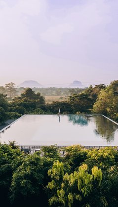Ein Pool in bewaldeter Landschaft mit Bergen im Hintergrund