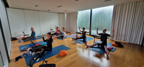 Gemeinsam Yoga üben im lichtdurchfluteten Yogaraum