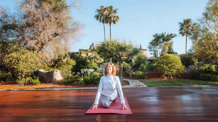 Frau übt Yoga auf einer Yogaplattform unter freiem Himmel
