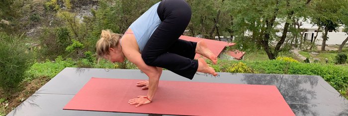 Cornelia Schäfer übt Yoga auf einer Plattform mit traumhaftem Ausblick.
