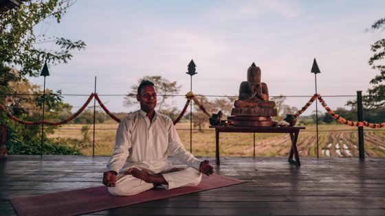 Mann meditiert auf einer Yogaplattform 