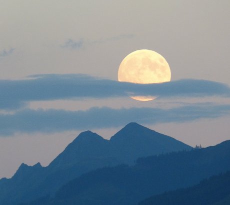 Ein heller Vollmond bei dunklem Himmel in der Dämmerung