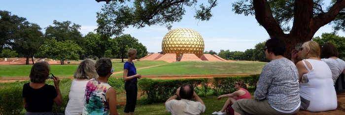Reiseleiterin Lisa Thole mit einer Gruppe vor dem Matrimandir in Auroville