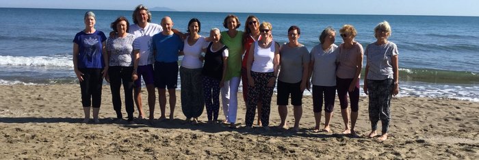 Die Yoga Gruppe genießt die letzten Sonnenstunden am Strand direkt vor der Tür
