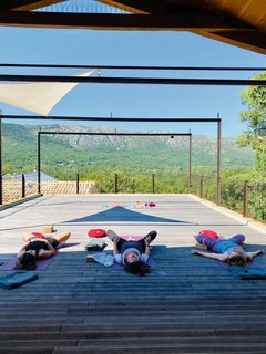Gemeinsam Yoga üben auf der Dachterrasse mit Blick auf die Berge