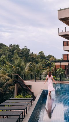 Eine Frau läuft auf dem Rand eines Pools