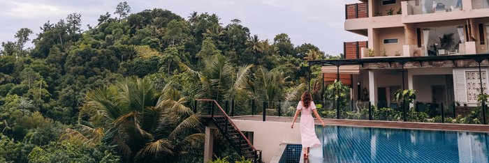 Eine Frau läuft auf dem Rand eines Pools