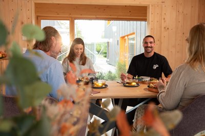 Mit anderen Gästen beim Essen zusammensitzen und austauschen