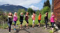 yoga-urlaub-deutschland-ifenblick-claudia-müller-krieger-zwei Die Gruppe in der Yoga-Haltung Krieger II.