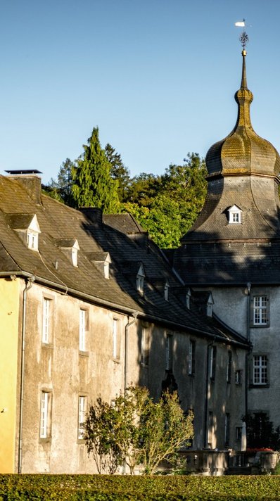 Das Schloss Melschede liegt umgeben von Buchenmischwäldern in einem weiten Tal im Sauerland