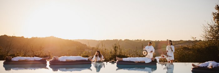 Vier Ayurveda-Gäste nehmen an einer Klang-Meditation auf dem Wasser teil