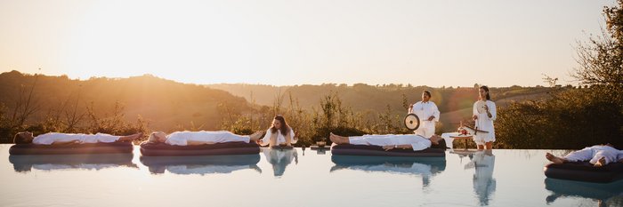 Vier Ayurveda-Gäste nehmen an einer Klang-Meditation auf dem Wasser teil