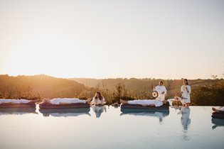 Vier Ayurveda-Gäste nehmen an einer Klang-Meditation auf dem Wasser teil